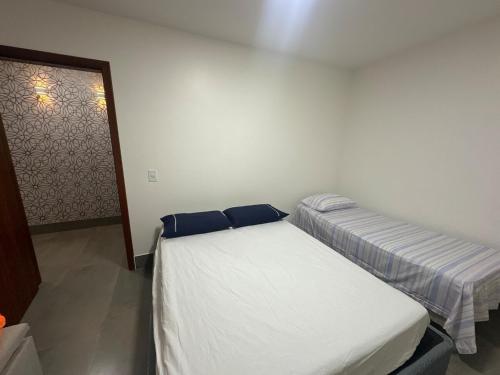a bedroom with two beds with blue pillows at Vila dos ventos in Marataizes