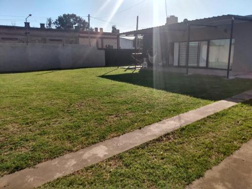 a backyard with a grassy yard next to a house at Hospedaje en San Nicolás in San Nicolás de los Arroyos