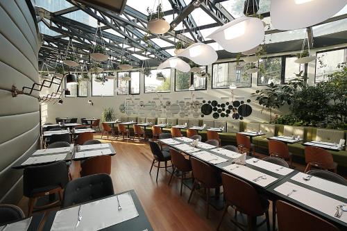 a dining room with tables and chairs and windows at Hotel Berthelot in Bucharest
