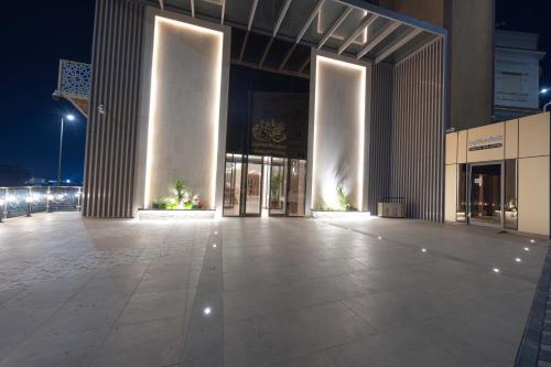 a large building with a lit up front at night at Sakura City Hotel in Al Baha