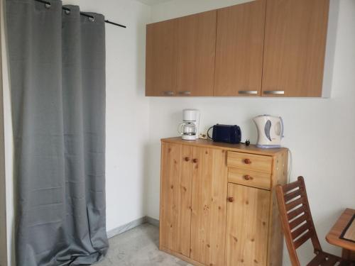 - une cuisine avec une commode en bois et une cafetière dans l'établissement studio meublé au port du cap, au Cap d'Agde