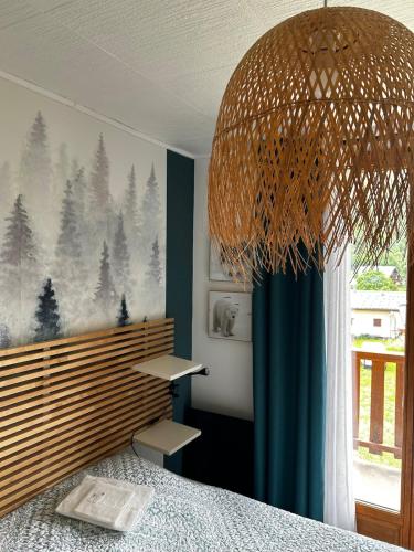 - une chambre avec un lit et un grand lustre dans l'établissement Beautiful apartment in independent chalet, à Valloire