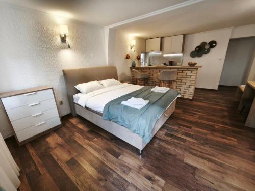 a bedroom with a large bed and a kitchen at Guest house Villa Slavica in Sveti Stefan
