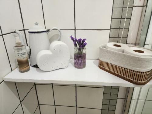 Un estante en un baño con papel higiénico y flores. en Sleep At Solomon 8A, en Kimberley