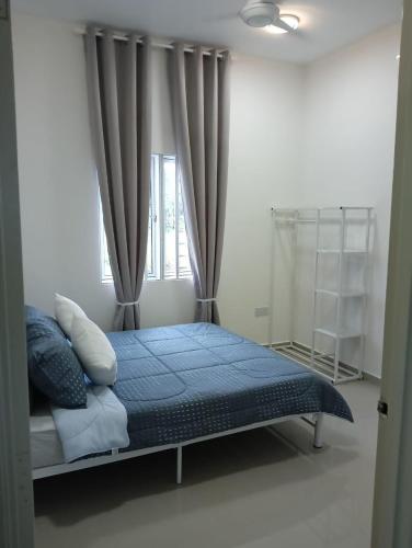 a bedroom with a bed with blue sheets and a window at D'Impian Umbai Homestay EPL, PS4, BBQ in Merlimau