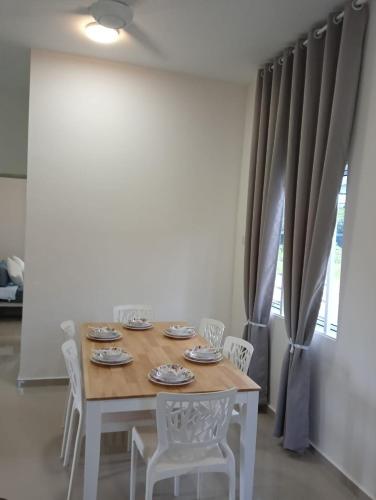 a dining room table with white chairs and a table and a window at D'Impian Umbai Homestay EPL, PS4, BBQ in Merlimau