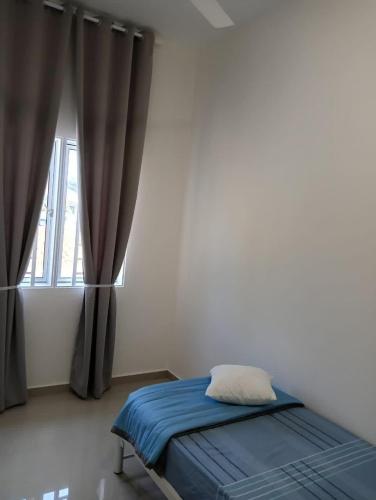 a bedroom with a bed with blue sheets and a window at D'Impian Umbai Homestay EPL, PS4, BBQ in Merlimau