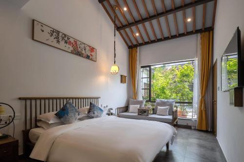 a bedroom with a large white bed and a window at 南京又见江南民宿 in Nanjing