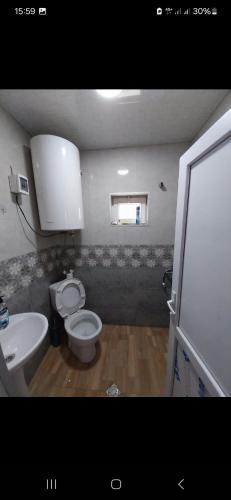 Un baño con un inodoro blanco y un lavabo. en Guesthouse Irma, en Mestia