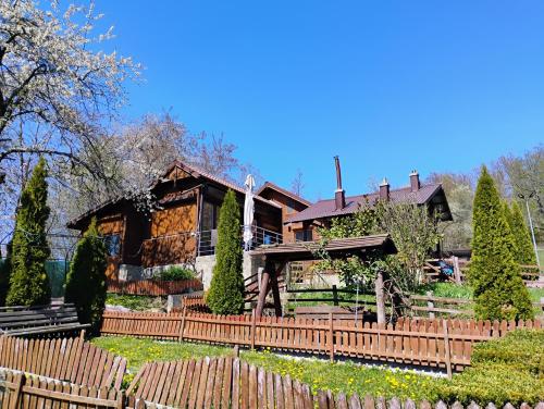 a house with a wooden fence in front of it at Cabana Elena - Private SPA in Brădetu