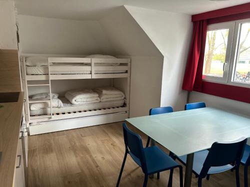 a room with a table and chairs and a bunk bed at Chouette appartement 5 personnes in De Haan