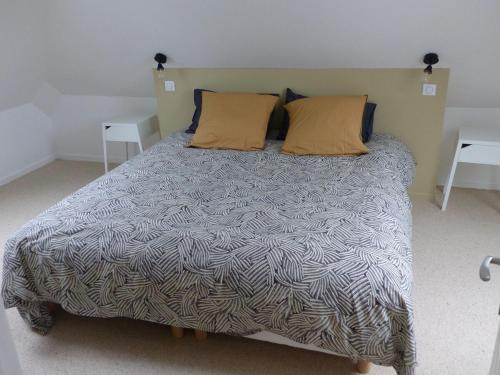 een bed met twee kussens erop in een slaapkamer bij Passage du Marché in Blainville-Crevon