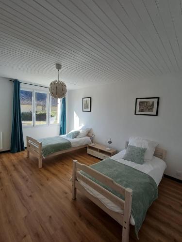 une chambre avec deux lits et une grande fenêtre dans l'établissement Charmante maison, entière au calme, sud avec jardin, à Chanteloup