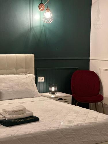 a bedroom with a bed and a red chair at La Grande Bellezza in Taranto