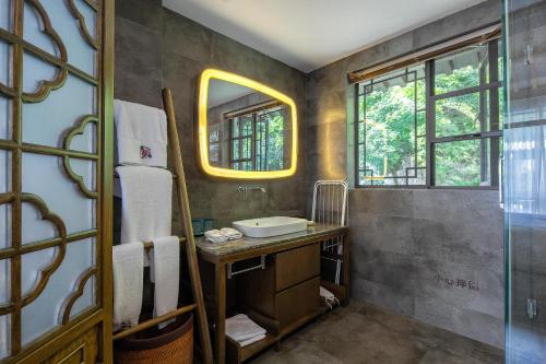 a bathroom with a sink and a mirror at 南京又见江南民宿 in Nanjing