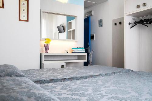 a bedroom with a bed and a sink and a mirror at Hotel Oceano in Marina di Pietrasanta