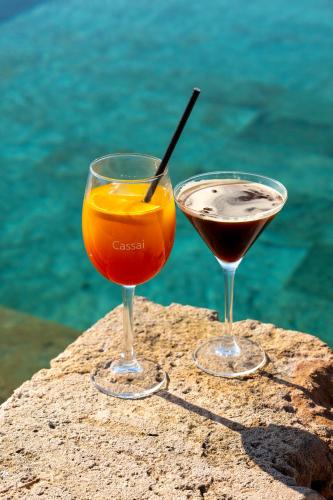 two cocktails sitting on a rock next to the water at Finca Hotel Rural Es Turó in Ses Salines