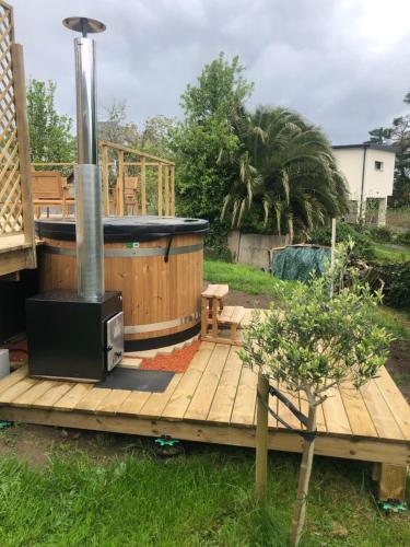 a deck with a hot tub and a stove at Ecolodge in Trébeurden