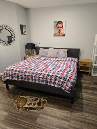 a bedroom with a bed with a plaid blanket on it at Rose room 8 in Newark