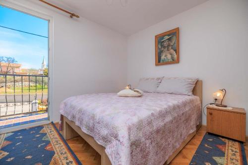 a bedroom with a bed and a large window at Apartments Kata in Malinska
