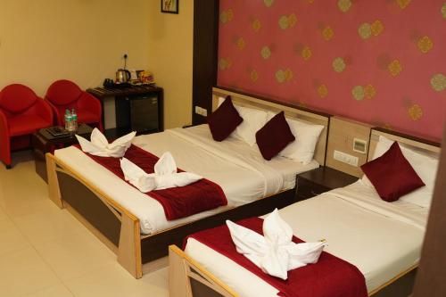 a room with two beds with red and white pillows at Hotel Rock Fort View in Tiruchchirāppalli