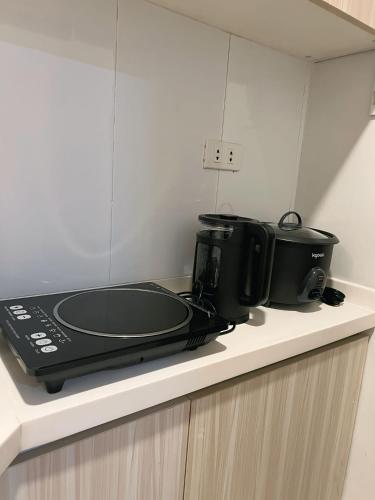 a black toaster oven sitting on top of a counter at Oyasumi Condotel with balcony-Megatowers 1 Near Session, SM, Burnham park, Baguio City in Baguio