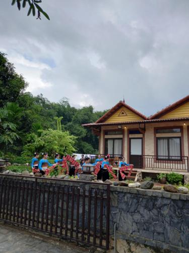 a group of people standing in front of a house at Mai Chau Xanh Bungalow in Mai Chau