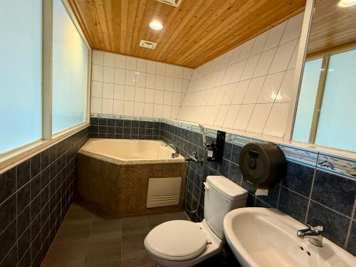 a bathroom with a tub and a toilet and a sink at 自在旅墅山莊 in Guoxing