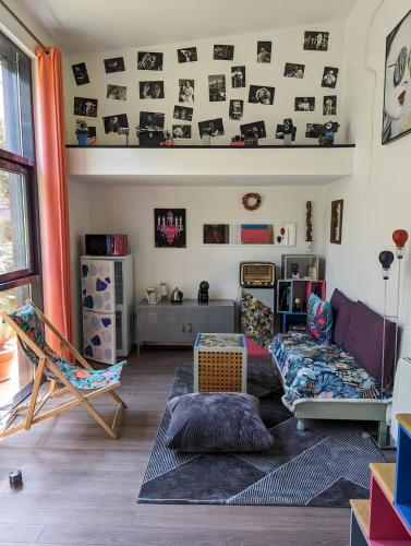 un salon avec un canapé et une chaise dans l'établissement Tiny House dans le jardin, à Boulogne-Billancourt