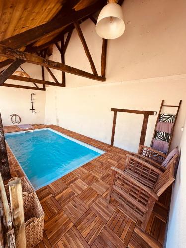 - une grande piscine avec 2 chaises dans une chambre dans l'établissement Maison Henriette, à Léré