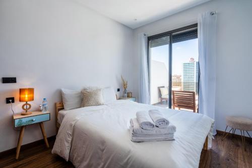 a bedroom with a white bed with towels on it at Studio Cosy Proche Gares & Mosqué Hassan II in Casablanca