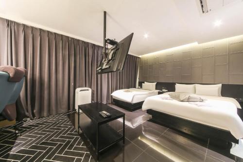 a hotel room with two beds and a tv at Hotel Yaja Sasang Terminal in Busan
