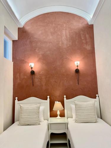 two beds in a room with a red wall at Charming of Olhao2 in Olhão
