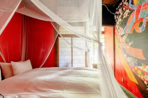 a bedroom with a canopy bed and a window at Villa Sacra in Kamakura