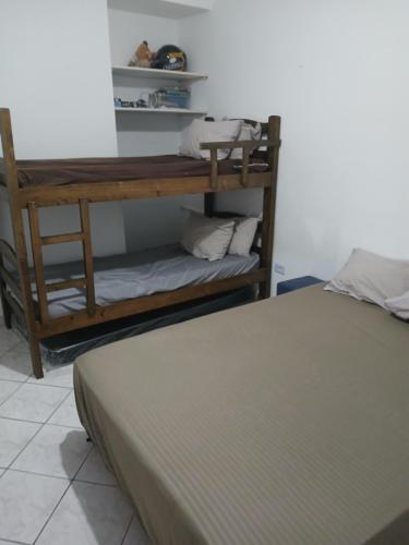 a room with a bed and a wooden shelf at Apartamento Estrela da Praia V19 in Mongaguá