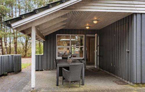 a patio with a table and chairs under awning at Stunning Home In Oksbøl With Sauna in Oksbøl