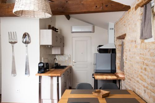 - une cuisine avec des murs blancs et un mur en briques dans l'établissement Gîtes l'Ora des Marais IV, à Sainte-Gemme-la-Plaine