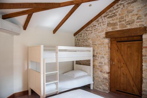 Ce lit superposé se trouve dans un dortoir doté d'un mur en briques. dans l'établissement Gîtes l'Ora des Marais IV, à Sainte-Gemme-la-Plaine