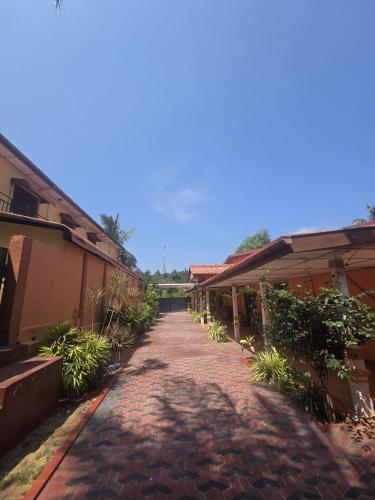 a cobblestone walkway between two buildings at Motel Apple Five in Trincomalee