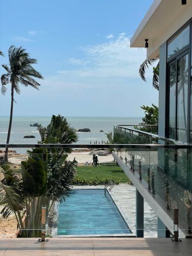 a house with a swimming pool next to a beach at Khalid’s House at the East coast in Phu Quoc
