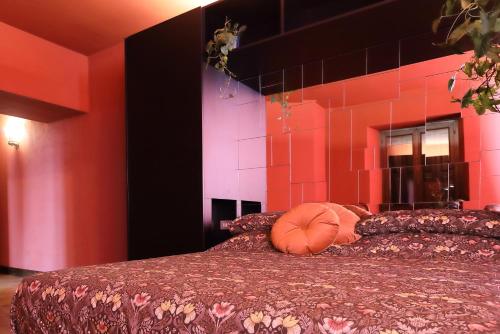 a bedroom with a bed with a orange pillow on it at Viscardo in Tarcento