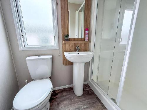 a bathroom with a toilet and a sink at 8 Berth Caravan With Decking And Wifi At Broadland Sands Park Ref 20064Cf in Hopton on Sea