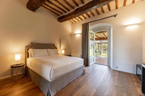 sypialnia z łóżkiem i otwartymi drzwiami w obiekcie Favorita Food&Wine Resort w mieście Bastia Umbra
