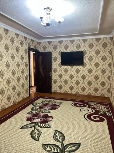 a room with a carpet with flowers on the wall at Aile Bukhara in Bukhara