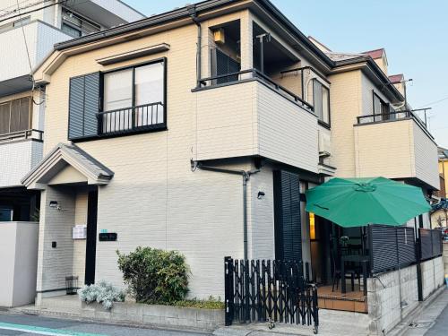 a house with a green umbrella in front of it at Lucky you! TATEISHI in Tokyo