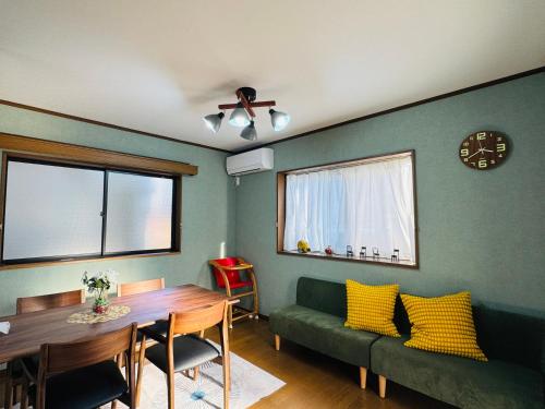a living room with a green couch and a table at Lucky you! TATEISHI in Tokyo