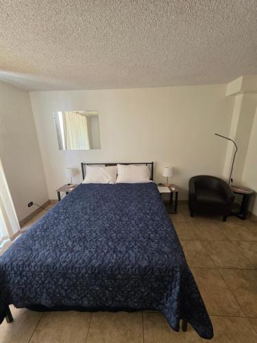 a bedroom with a bed and a chair in it at Waikiki Vacation Condo in Honolulu