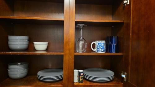 a cabinet with plates and cups and dishes in it at Waikiki Vacation Condo in Honolulu