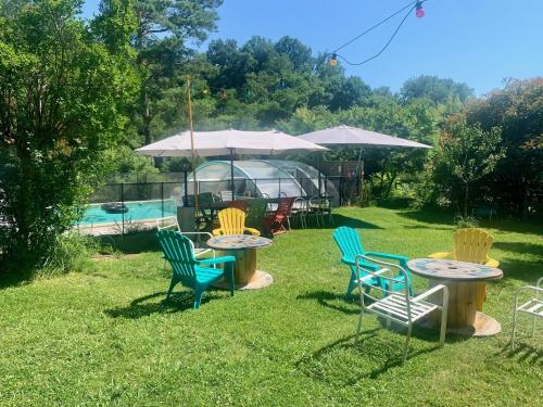 a group of chairs and tables in a yard at Gîte Vanakam 3 étoiles- jolie maison béarnaise 9 personnes avec piscine in Sault-de-Navailles