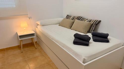 莫哈卡尔Mojacar 1ª linea playa vacaciones的客房内的一张带两个枕头的白色床